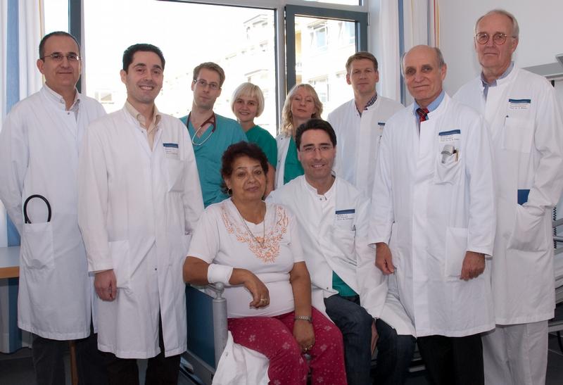 Das erfolgreiche "Klappenteam" aus der Kardiologie, Angiologie und Pneumologie des Universitätsklinikums Heidelberg von links nacht rechts: Dr. Derliz Mereles, Privatdozent Dr. Raffi Bekeredjian, Dr. Sven Pleger, Sabrina Koch, Dr. Ulrike Krumsdorf, Privatdozent Dr. Wolfgang Rottbauer, Privatdozent Dr. Klaus Kallenbach, Prof. Hugo A. Katus, Ärztlicher Direktor der Kardiologie, Angiologie und Pneumologie und Prof. Eike Martin, Ärztlicher Dirketor der Anästhesiologie des Universitätsklinikums Heidelberg, mit der Patientin in der Mitte.