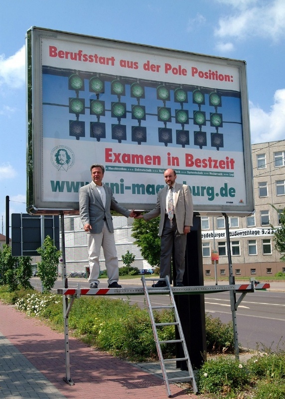 Uni-Professor Volker Linneweber (li), Klaus Hennicke, Niederlassungsleiter der Ströer City Marketing GmbH (re), vor dem Megalightposter am Pfälzer Platz