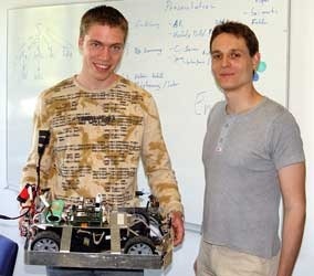 Christian Layh (rechts) und Daniel Eck mit einem der Merlin-Roboterfahrzeuge, die am Lehrstuhl für Technische Informatik entwickelt werden. Foto: Rajesh Shankar Priya