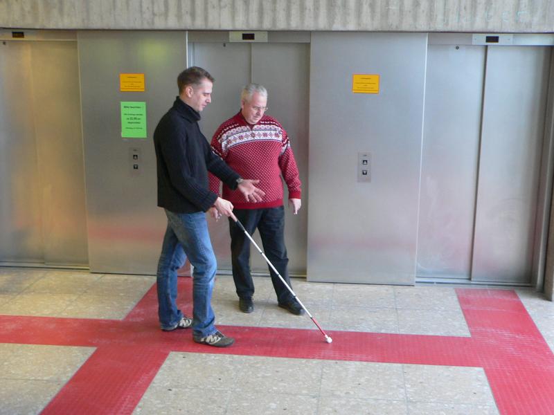 Gregor Köwing, Rehabilitationslehrer der Nikolauspflege, testet mit Peter Bork das neue Blindenleitsystem.
