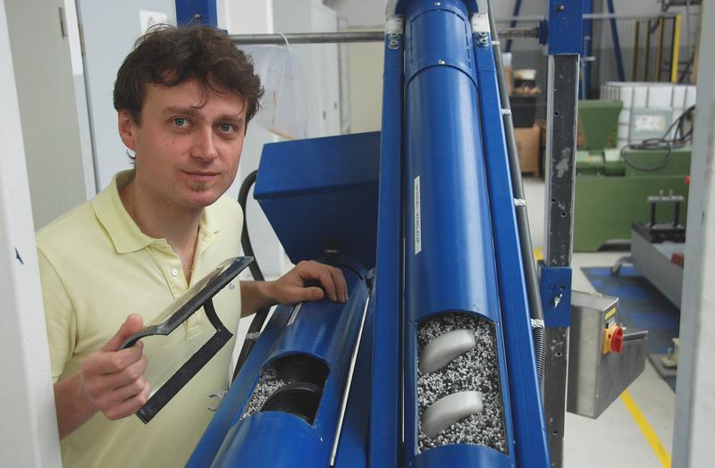 Arndt Schumann von der Professur Fördertechnik gibt einen Einblick in die Förderanlage, in der die neu entwickelte Kunststoffspirale zum Einsatz kommt.