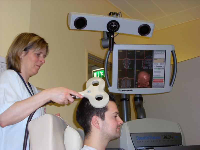 Bei der schmerztherapeutischen Anwendung der transkraniellen Magnetstimulation in der neurochirurgischen Ambulanz am UKJ wird durch eine Magnetspule von außen ein starkes Magnetfeld auf die schmerzauslösenden Hirnareale gerichtet.