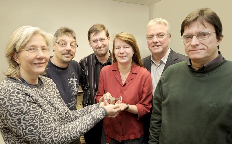 Wissenschaft ist Teamarbeit: Anja Honig, Thomas Reich, Dr. Oliver Ott, Dr. Annette Röttger, Dr. Dirk Arnold und Dr. Rainer Dersch (v.l.) präsentieren das Emanationsgefäß, dessen Entwicklung besonders viel Zeit gekostet hat. Es enthält eine Th-228-Quelle, aus der durch radioaktiven Zerfall Thoron (Rn-220) entsteht. Dank dieses Bauteils gelang es mit einer weltweit einzigartigen Genauigkeit festzustellen, wie viel Thoron abtransportiert wird und wie viel in der Quelle bleibt.
