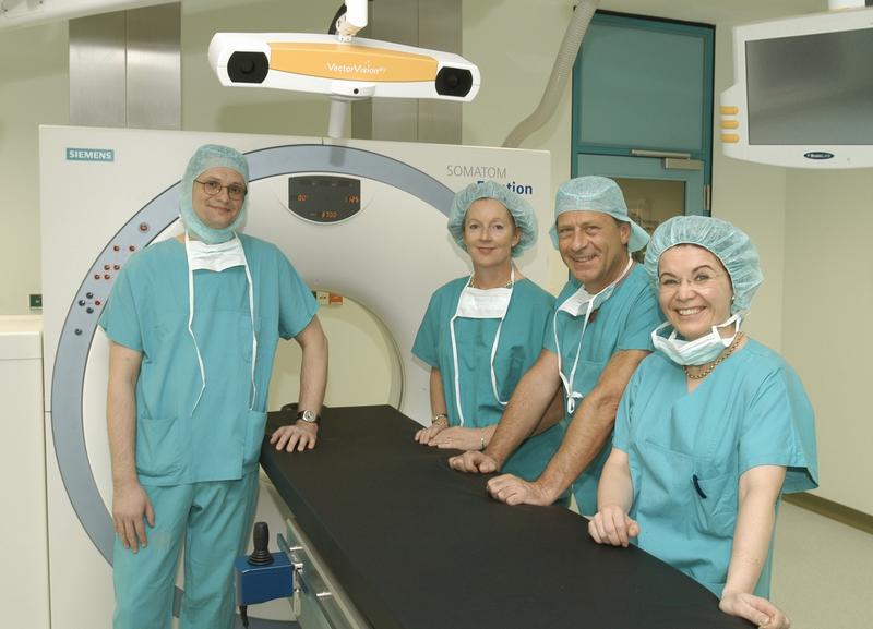 Vor dem neuen intraoperativen Computertomographen (von links): Dr. Dr. Rüdiger Marmulla (Klinik und Poliklinik für Mund-, Kiefer- und Gesichtschirurgie), Irmtraut Gürkan (Kaufmännische Direktorin des Universitätsklinikums Heidelberg), Prof. Dr. Dr. Joachim Mühling und Dr. Dr. Bibiana Kotrikova (Klinik und Poliklinik für Mund-, Kiefer- und Gesichtschirurgie).