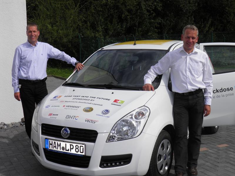 Prof. Dr.-Ing. Peter Kersten (links) und Prof. Dr.-Ing. Jürgen Krome vor dem Elektroauto Stromos.