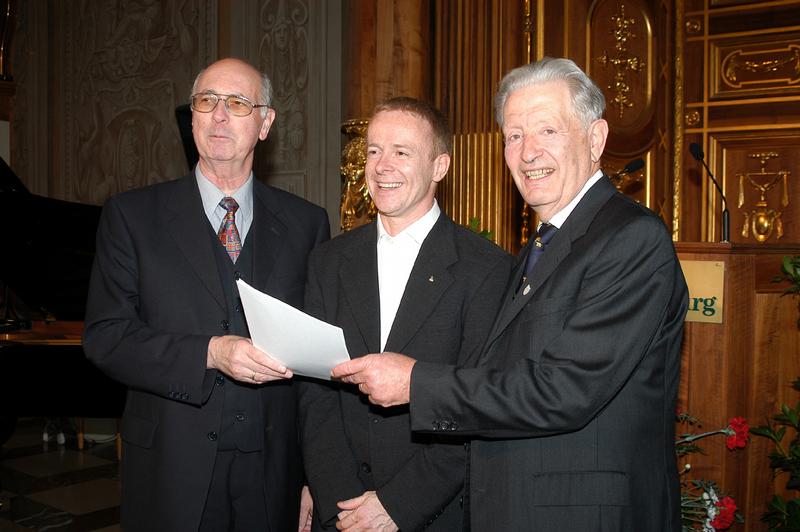 ... auf P. Dr. Jörg Alt SJ (mitte), der die Auszeichnung am 10. Mai 2004 im Goldenen Saal des Augsburger Rathauses aus den Händen des Preisstifters Helmut Hartmann (rechts) und des Jury-Vorsitzenden Prof. Dr. Dr. h. c. mult. Wolfgang Frühwald entgegennahm.