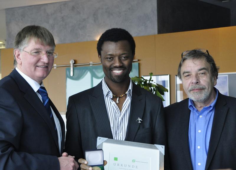 Narcisse Njoya Ngatat zusammen mit DSW-Präsident Prof. Dr. Rolf Dobischat (re.) und dem Geschäftsführer des Siegener Studentenwerks Detlef Rujanski