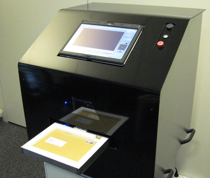 So sieht das von Fraunhofer IPM gemeinsam mit den Firmen Hübner GmbH in Kassel und IANUS Simulation GmbH in Dortmund entwickelte Terahertz-Briefspektrometer »T-Cognition 1.0« aus. Eine Schublade zieht die Briefe in das System. Per Knopfdruck wird die Sicherheitsprüfung gestartet. Auf dem Touchscreen wird per Farbsignal angezeigt, welche gefährlichen Stoffe (Sprengstoffe und/oder Drogen) an welcher Stelle in der Post nachgewiesen wurden.