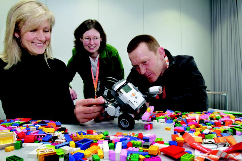 Tessa Waack und Michael Sommer von der Sekundarschule »Ernst Wille« aus Magdeburg bauen einen Roboter mit Hilfe von Workshop-Leiterin Birgit Koch-Sickmann.