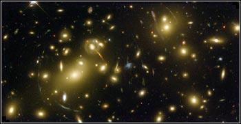 Ferne Galaxien werden durch Gravitationslinseneffekte verzerrt. Viele von ihnen enthalten wie die Milchstraße schwarze Löcher in ihren Zentren, die als "Monster" Gas und Sterne aufsaugen und enorme Energie abstrahlen.