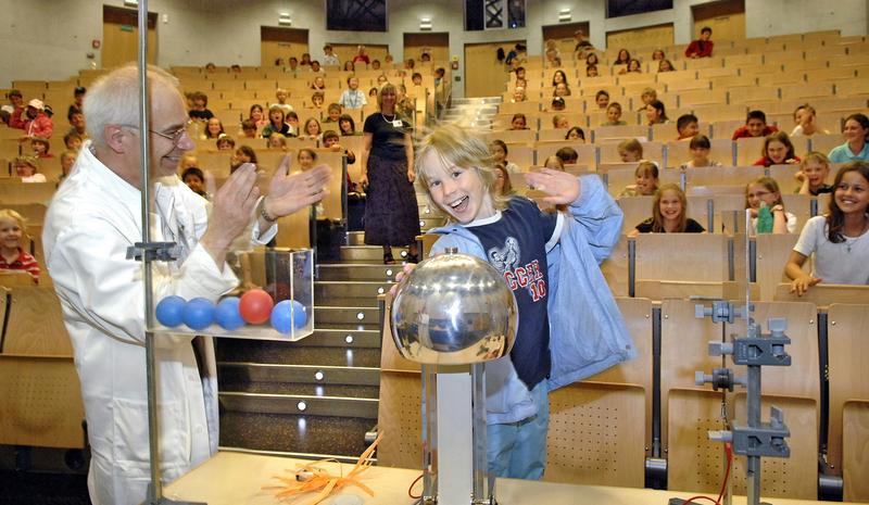 Professor Dr. Peter Claus lässt dem Kinder-Uni-Studenten Jonas in der Vorlesung „Blitz und Donner“ die Haare zu Berge stehen. 