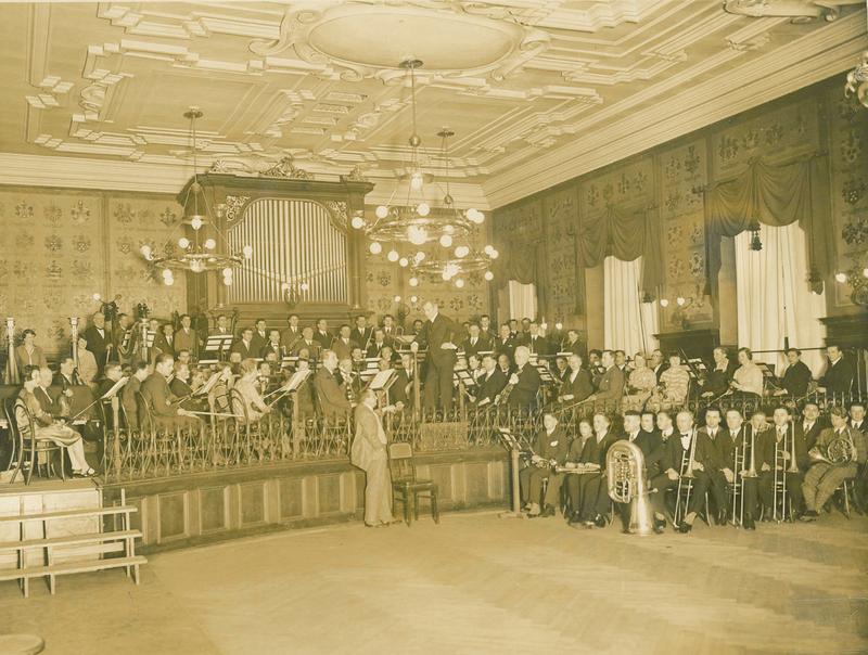 Saal des Konservatoriums für Musik Würzburg 1929 mit Orchester unter der Leitung von Karl Muck. Vor der Bühne steht Hermann Zilcher, langjähriger Direktor des Konservatoriums sowie Gründer des Mozartfestes Würzburg.