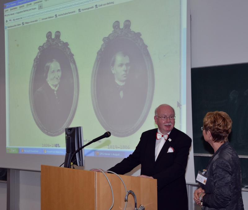 Christian-Ulrich Behring und Dr. Ulrike Enke beim Freischalten der Datenbank behring digital. Auf der Projektion sind Urgroßtante und –onkel Behrings zu sehen, die Eltern des Nobelpreisträgers Emil von Behring.