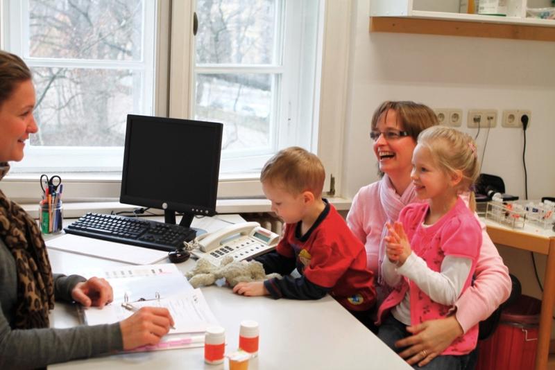 Studienärztin Dr. med. Anna Huppert beim Ausfüllen des Fragebogens zur Pre-POINT-Studie mit Katharina M. und ihren Kindern Nick und Amelie
