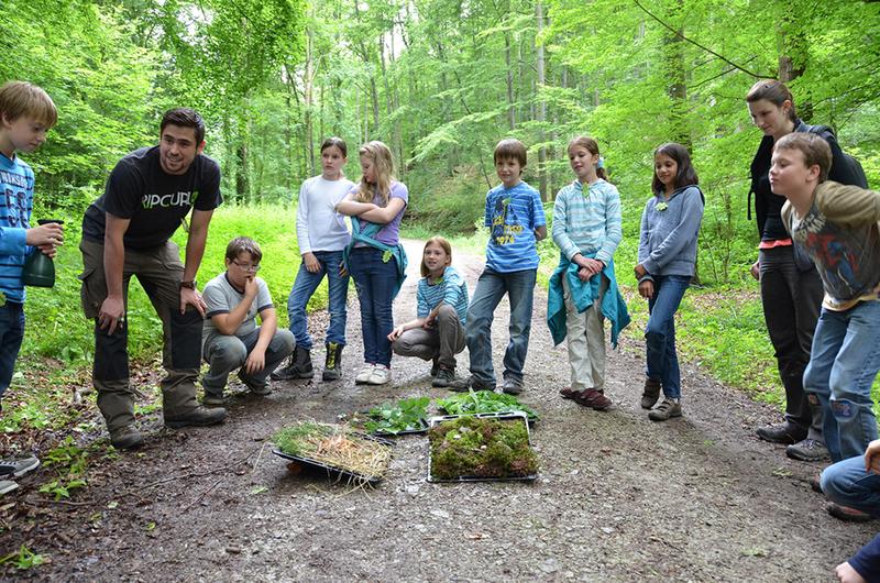 Die beiden HAWK-Studierenden Steffen Wilhelm und Lara Laubner probieren mit den Kindern der Klasse 4b der Wilhelm Henneberg Schule Göttingen, wie schnell ein Wald in Brand geraten kann.