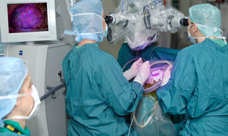 Während der Operation durch die Neurochirurgen des UKJ kann unter speziellem UV-Licht des Operationsmikroskops der zu entfernende Hirntumor deutlich sichtbar vom gesunden Hirngewebe unterschieden werden. 