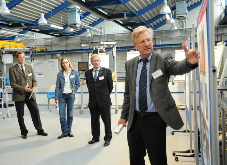 Programmpunkt des Runden Tischs ist eine Laborführung an der Hochschule OWL, hier im Labor Industrial Engineering von Professor Wilfried Jungkind (rechts) und Professor Sven Hinrichsen.