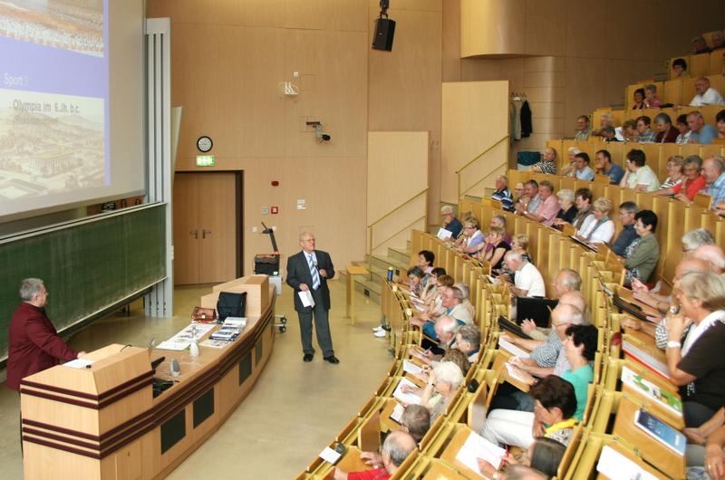 Der Beauftragte für die Seniorenakademie, Dr. Wolfgang Friedrich (2. v. li.), und der Referent der Auftaktveranstaltung des Wintersemesters, Prof. Dr. Karlheinz Wohlgefahrt (li.), mit Teilnehmern im großen Hörsaal des Konrad-Zuse-Medienzentrums. 