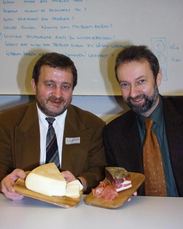 Prof. Dr. Joachim Roll (r.) von der Fachhochschulabteilung Recklinghausen und Prpf. Michel Cans (l.) von der Hochschule in Sitten besiegelten die neue Kooperation mit dem Tausch von typischen Produkten ihrer Hochschulregion. Foto: FHG/BL