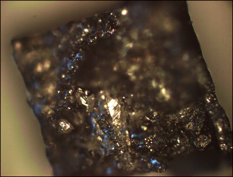 Diamanthaltiges Gestein, das im Hochdruck-Laboratorium des Bayerischen Geoinstituts hergestellt wurde. Es hat die gleiche chemische Zusammensetzung wie Diamantgestein in rund 180 Kilometern unter der Erdoberfläche. Die Forschungstechnologien im BGI ermöglichen eine präzise Simulation der Druckverhältnisse und der Temperaturen in verschiedenen Schichten des Erdinneren. – Die hier abgebildete Gesteinsprobe hat einen Durchmesser von 3 Millimetern, das weiß glänzende Gestein in der Mitte ist ein Diamant.
