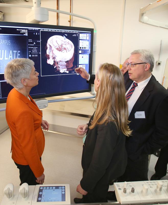 Prof. Dr. Martin Skalej (re.), Direktor des Instituts für Neuroradiologie am Universitätsklinikum Magdeburg, erläutert Staatssekretärin Cornelia Quennet-Thielen (li.) vom Bundesministerium für Bildung und Forschung und der Wissenschaftsministerin des Landes Sachsen-Anhalt, Prof. Dr. Birgitta Wolff (Mi.), die Möglichkeiten bildgeführter minimal-invasiver Behandlungsmethoden in der Medizin.