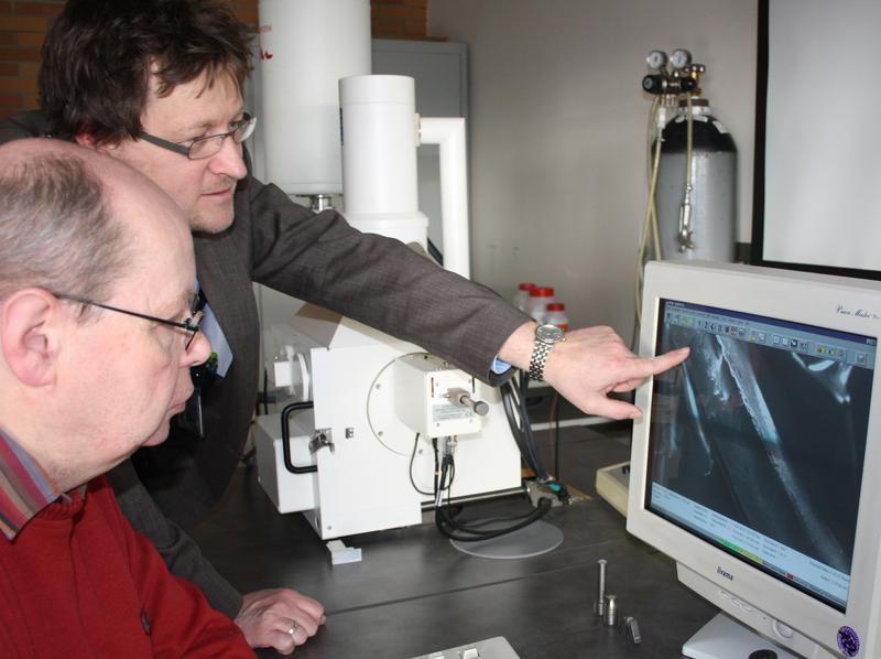 Prof. Jörg Gollnick (hinten) und Laboringenieur Lothar Pfeil analysieren am Rasterelektronenmikroskop Bruchbilder von Stahlproben.
