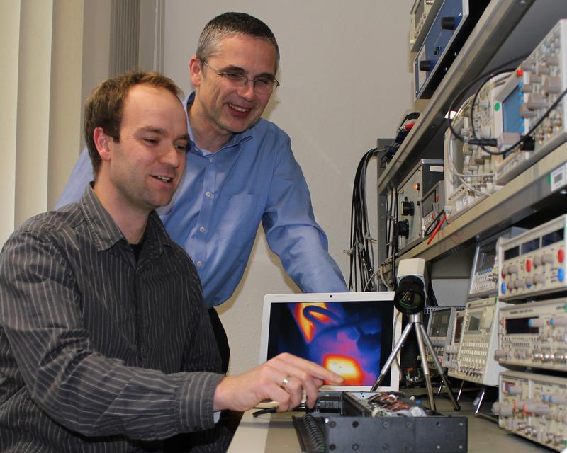 Das Team um Prof. Dr. Christian Pätz (r.) und Daniel Froß von der Stiftungsprofessur für Systemzuverlässigkeit in Elektromobilität und Energiemanagement stellt auf der CeBIT ein Testlabor für intelligente Stromschaltleisten vor. Die Leisten werden unter anderem mit einer Wärmebildkamera untersucht. 