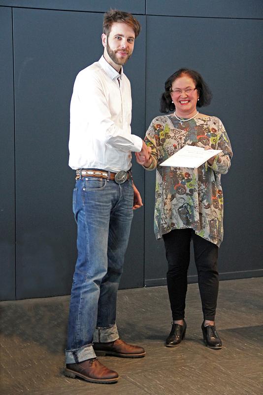 Daniel Kwittung erhält die Urkunde zur Verleihung des Friedrich-Wingert-Preises aus den Händen von Dr. Beatrice Moreno vom Berliner Software-Unternehmen ID, die das Projekt SIMPLE leitet, anlässlich der Abschlussfeier an der Hochschule Ulm.