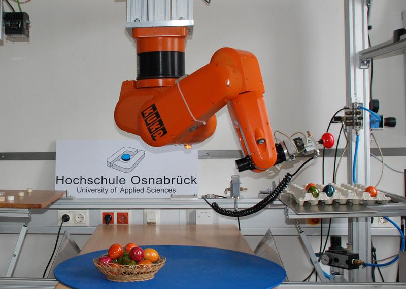 Gleich landet auch das rote Ei in der Packung: Der Industrieroboter aus dem Labor für Regelungstechnik und digitale Signalverarbeitung an der HS Osnabrück wurde von Mechatronik-Studierenden für diese Aufgabe programmiert.