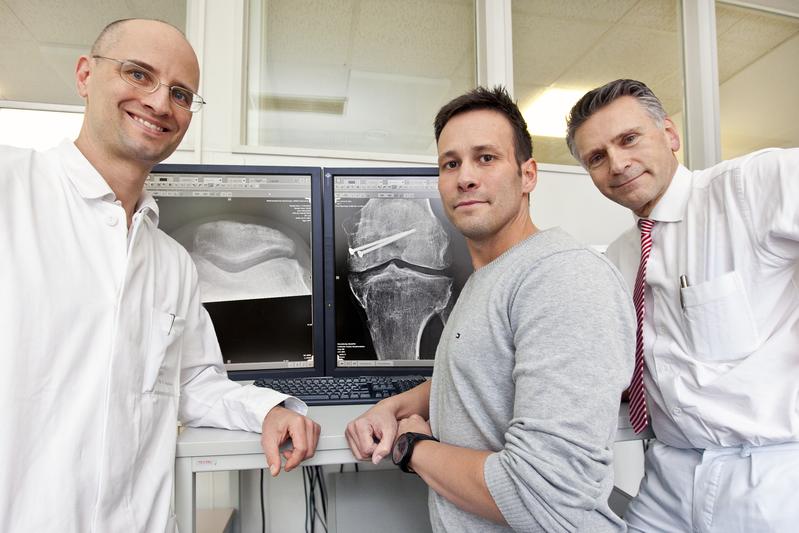 Professor Dr. Michael Jagodzinski, Patient André S. und Professor Dr. Christian Krettek (von links nach rechts) vor dem Röntgenbild des Knies von André S.