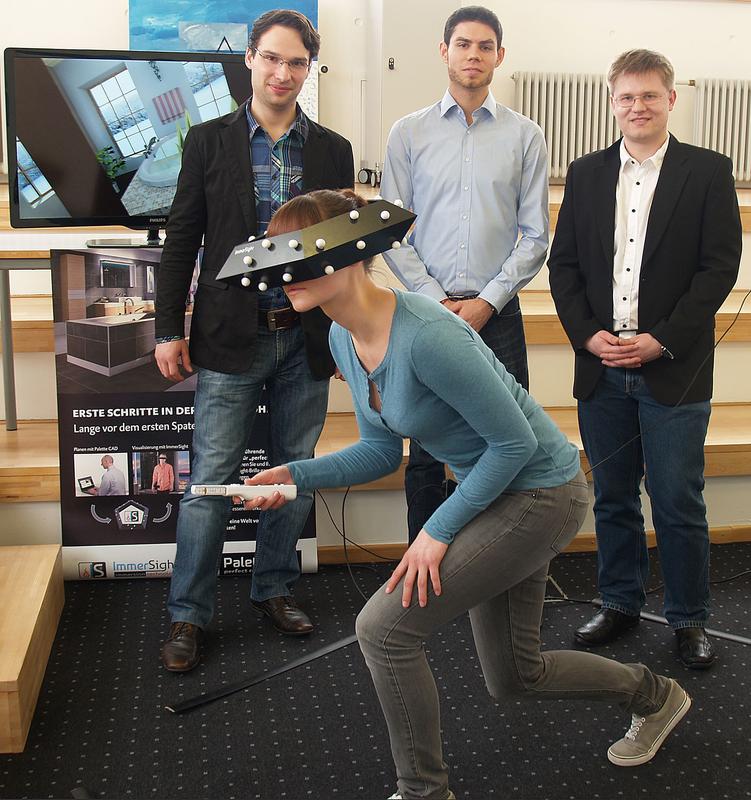 Fabian Weiss, Simon Singler und Stefan Hörmann von Immersight (v.l.) machen Ausflüge in virtuelle Welten möglich: Dank einer von ihnen und Dominik Nuss entwickelten Videobrille kann die Nutzerin vorne im Bild ein Bad inspizieren, das es noch gar nicht gibt. Die entsprechende Planungsvisualisierung ist auf dem Bildschirm zu sehen