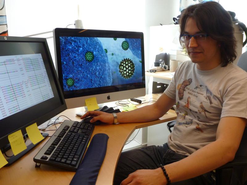 Dr. Alexander Suh at work in front of his PC. The screen depicts hepatitis B viruses 