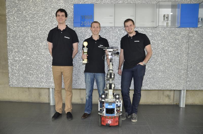 Das Team SmartBots@Ulm der Hochschule Ulm wurde mit dem Serviceroboter Kate Vizemeister in der Kategorie Robocup@Home beim RoboCup German Open 2013 in Magdeburg. Von links nach rechts: Matthias Hörger, Johann Haller und Andreas Gollack mit Kate und Pokal.