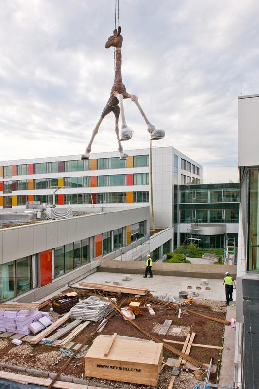Die sieben Meter hohe Giraffe schwebt im Innenhof der neuen Frauen- und Haut-Klinik des Universitätsklinikums Heidelberg ihrem neuen Standort entgegen. 