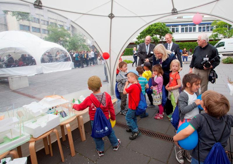 Thomas Platte, Direktor Hessisches Baumanagement Frankfurt am Main, Eva Kühne-Hörmann, Hessische Ministerin für Wissenschaft und Kunst, und FH-Präsident Dr. Detlev Buchholz (v.l.n.r.) besuchen die Ausstellung von Kita-Kindern, die in den Lernwerkstätten der FH Frankfurt ihre „Traum-Kita“ entworfen haben.