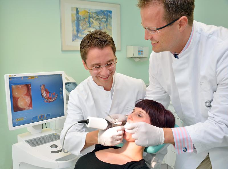 2)	Dr. Oliver Schäfer und Privatdozent Dr. Arndt Güntsch von der Zahnklinik am UKJ fertigen einen digitalen Abdruck vom Gebiss der Patientin an.
