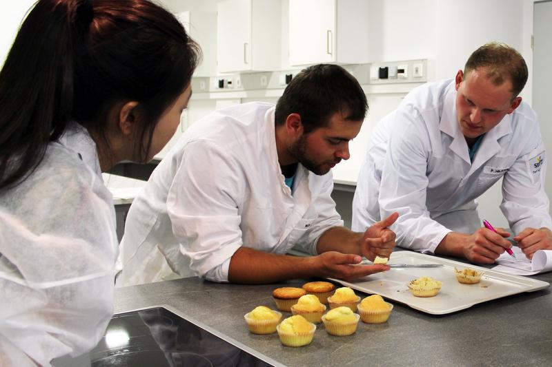 Juyoung Kim, Sven Sackewitz und Philipp Hilker überprüfen den Geschmack und die Konsistenz ihrer selbstgebackenen Muffins. Ihre Kommilitonen müssen im Anschluss bewerten, welche Muffin-Rezeptur am besten schmeckt.
