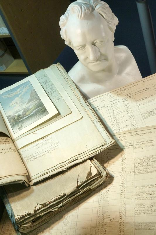 Historische Wetterbeobachtungskarten aus der Anfangszeit der Jenaer Klimastation neben einer Büste von Johann Wolfgang von Goethe. Unmittelbar nachdem unter der Oberaufsicht Goethes die Sternwarte Jena im September 1813 in Betrieb gegangen war, nahm auch die Klimastation ihre Arbeit auf. Goethe selbst veranlasste die regelmäßige Aufzeichnung der Wetterdaten, um möglichst exakte Prognosen für die Sternbeobachtungen erstellen zu können. 