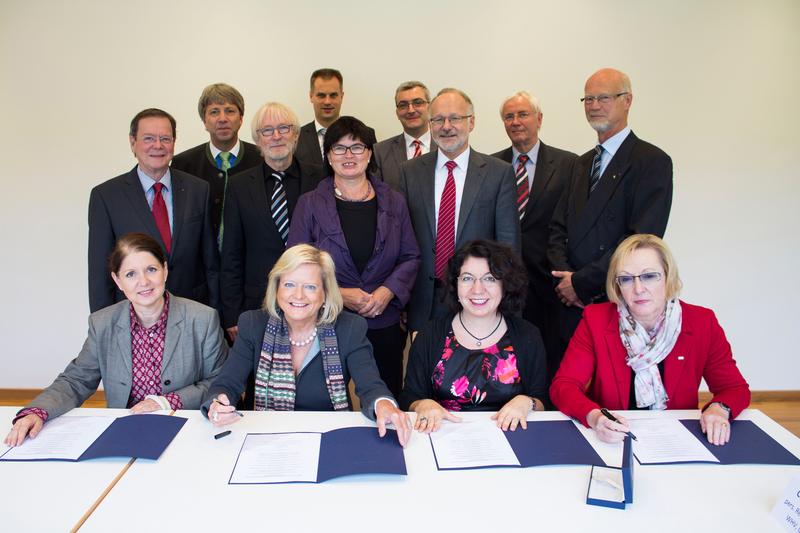 Unterzeichnung der Absichtserklärung, vorn sitzend v. li.: Claudia Baumgärtner (Jade Hochschule Wilhelmshaven, Oldenburg und Elsfleth), Prof. Dr. Gunilla Budde (Vizepräsidentin der Carl von Ossietzky Universität Oldenburg), Prof. Dr. Yasemin Karakaşoğlu (Vizepräsidentin der Universität Bremen), Prof. Dr. Marianne Assenmacher (Präsidentin der Universität Vechta); hintere Reihe stehend v. li.: Prof. Dr. Erhard Mielenhausen (Rotary-Distrikt-Governor 2013-2014), Dr. habil. Elmar Schreiber (Präsident Jade Hochschule Wilhelmshaven, Oldenburg, Elsfleth), Prof. Dr. Dr. h.c. Josef Stockemer (Rektor Hochschule Bremerhaven, Prof. Dr. Alexander Schmehmann (Vizepräsident Hochschule Osnabrück), Prof. Dr. Karin Luckey (Rektorin Hochschule Bremen), Derk H. Schönfeld (Universität Bremen), Prof. Dr. Gerhard Kreutz (Präsident Hochschule Emden/Leer), Prof. Dr.-Ing. Claus Rainer Rollinger (Präsident Universität Osnabrück), Remmer Edzards (Rotary-Distrikt-Governor 2015-2016). 