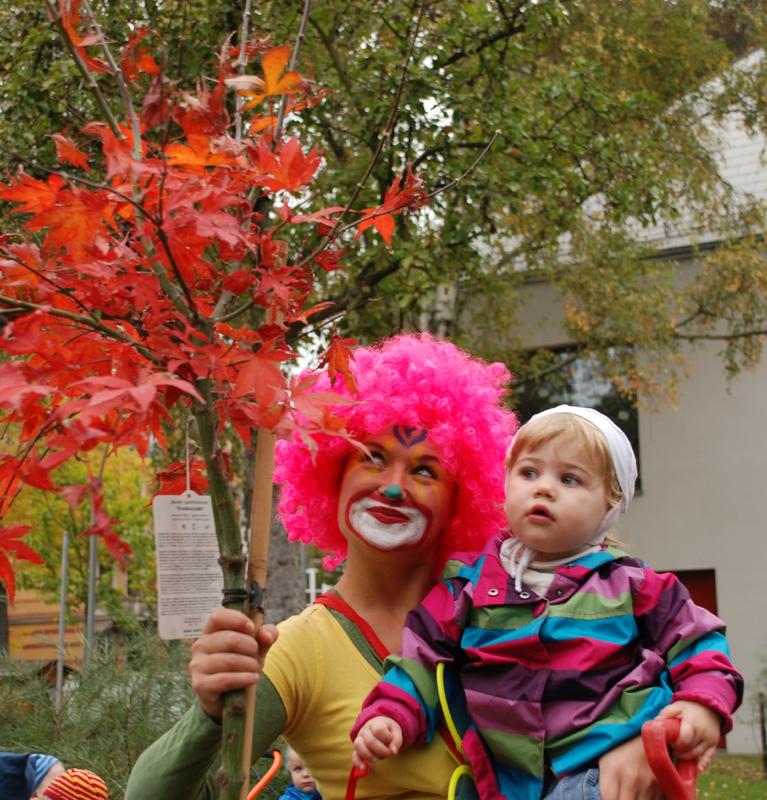 Sandra Herrmann, Mitarbeiterin des Präventionszentrums am UCC, kam als Clown Zitzewitz zur Kindertagesstätte „Gäste der Buche“ der Arbeiterwohlfahrt, um mit Krippenkindern die neuen Bäume zu pflanzen.