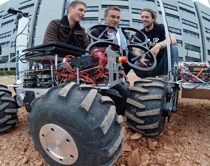 Max Uhlig, Dr. Niko Sünderhauf und Peer Neubert (v.l.) vom Robotics-Team testen auf dem Campus der TU Chemnitz das Zusammenspiel der Bodenroboter und des Quadrocopters.
