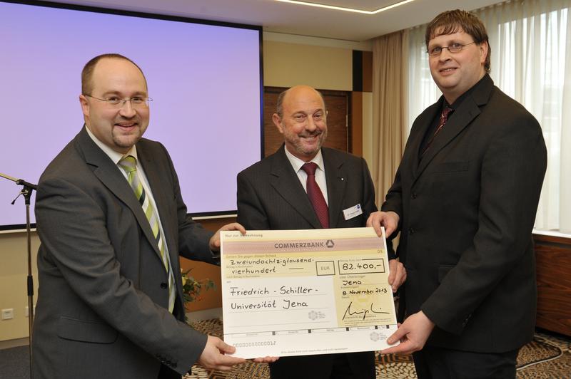 Prof. Dr. Michael Stelter (l.) und PD Dr. Achim Stolle (r.) von der Universität Jena nehmen den Förderscheck aus den Händen von Dr. Dieter Hübl vom VCI entgegen. 