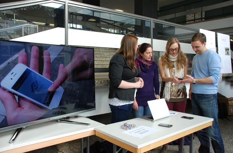 Saskia Meier, Dunja-Magdalena Grieger und Ina Kleemann haben mit 9 Kollegen eine App für die Raumsuche auf dem Hochschulcampus entwickelt und zeigen sie dem Doktoranden Alexander Giertler.