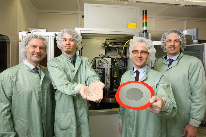 Wafer und separierte Mikrochips: Die Preistraeger Dr. Hans-Ulrich Zühlke, Dirk Lewke, Dr. Matthias Koitzsch und Dr. Martin Schellenberger (v.l.) vor einem TLS-Dicer des Fraunhofer IISB in Erlangen.