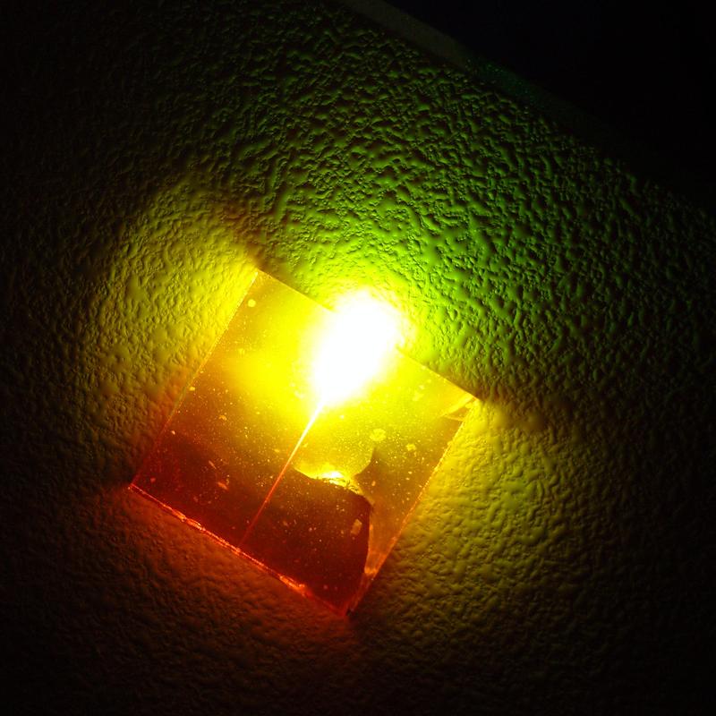 Infrarot-Laserstrahl trifft auf ein mit seltenen-Erden-dotiertes Glas und wird dabei zu sichtbarem Licht umgewandelt (Demonstrationsfoto)