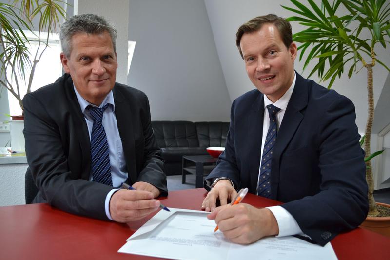 Volker Bargfrede (l.) und Prof. Kai Kummert unterschreiben die Forschungskooperation zur Optimierung von Energiesystemen in Verwaltungsgebäuden.