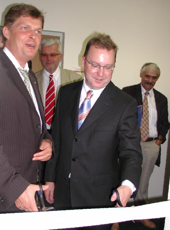 Nach der feierlichen Schlüsselübergabe durchschnitten Staatssekretär Prof. Dr. Markus Karp (li.) und Stiftungsprofessor Dr. Detlef  Wehling das Band vor der Tür zum neuen Gründer- und Entwicklungszentrum.