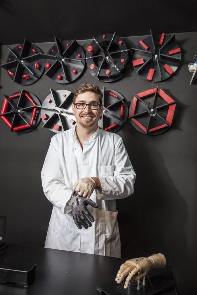 Ein Doktorand bereitet das Setup für Greifversuche mit einem Datenhandschuh und einem Objektkarussell vor. 