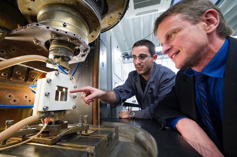 Prof. Dirk Bähre (r.) und Dipl.-Ing. Olivier Weber beobachten eine Probe beim elektrochemischen Abtragen: Das Verfahren ermöglicht, maßgefertigte Metall-Bauteile in großer Zahl günstig herzustellen.