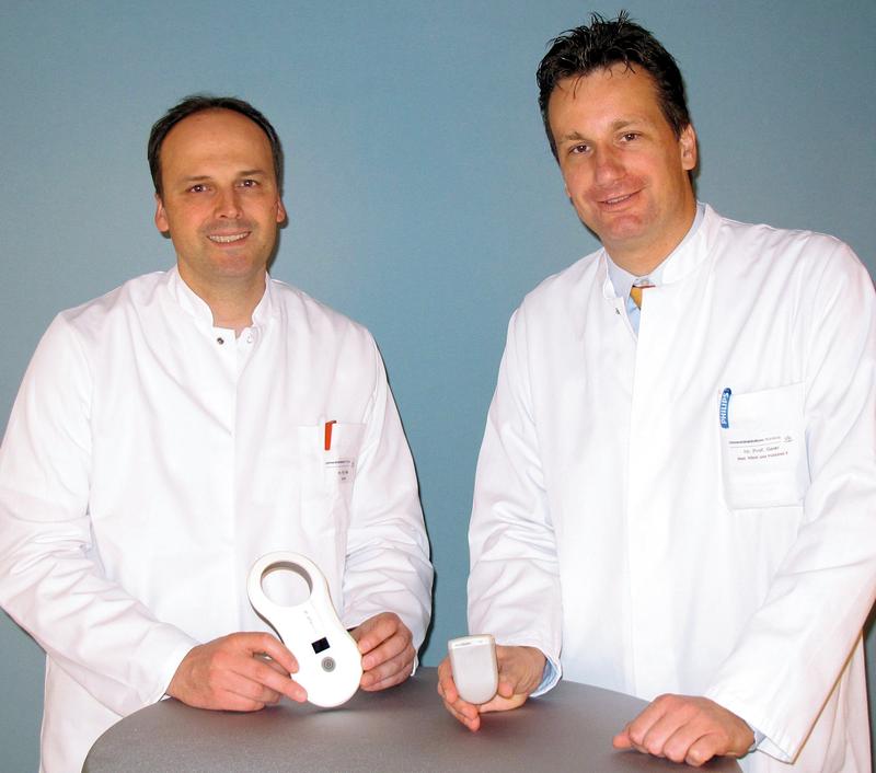 Prof. Ingo Klein (links, mit Ladegerät) und Prof. Andreas Geier (mit der Aszites-Pumpe) vom Universitätsklinikum Würzburg haben die weltweit ersten Patienten mit dem neuen System versorgt